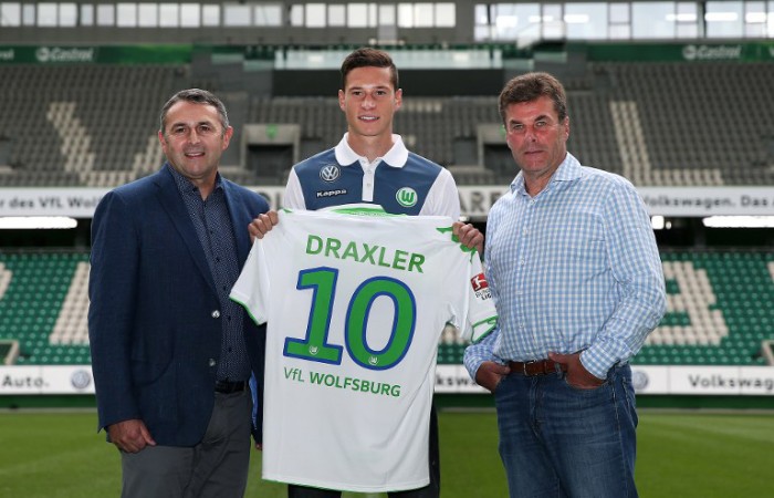 Julian Draxler posiert mit Wolfsburg's Sportdirektor Klaus Allofs (L) und Trainer Dieter Hecking (R) in der Volkswagen-Arena in Wolfsburg am 1.September 2015. AFP PHOTO / RONNY HARTMANN