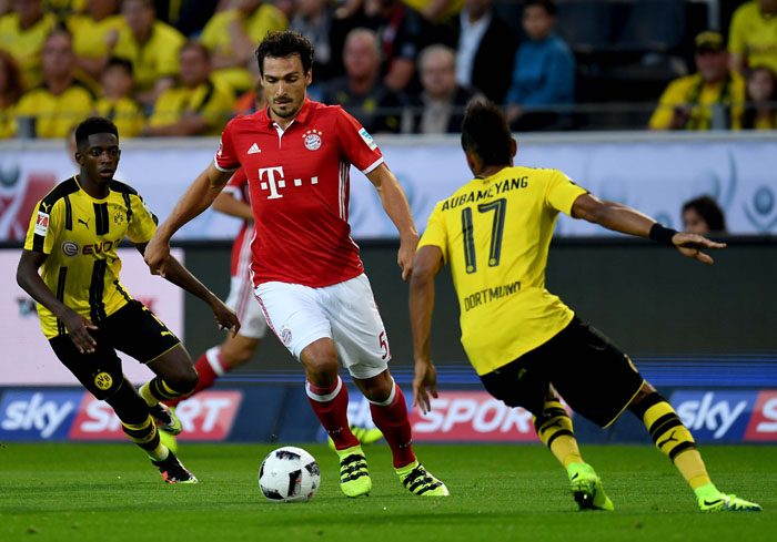 Bayern Münchens Abwehrspieler Mats Hummels (C) gegen Pierre-Emerick Aubameyang am 14.August 2016. / AFP PHOTO / PATRIK STOLLARZ