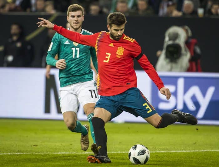 Timo Werner am 23.März 2018 im neuen grünen Away Trikot 2018 gegen Spanien - vorne Gerard Pique im neuen Spanien-Trikot 2018 (Foto AFP)