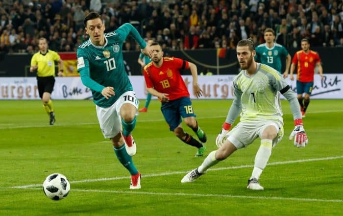Mesut Özil im neuen Wm Trikot mit der Rückennummer 10, der spanische Torwart David de Gea (R) beobachtet am 23.März 2018 beim Testspiel gegen Spanien. / AFP PHOTO / Odd ANDERSEN