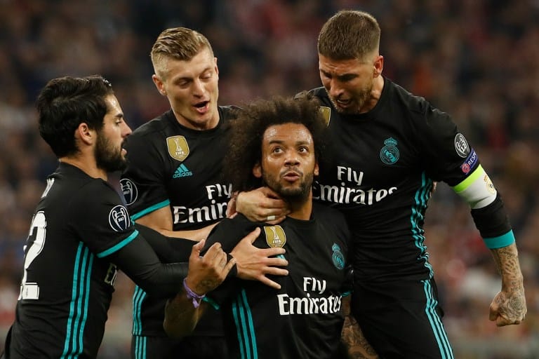 Im Real Madrid Ausweichtrikot: Real Madrid’s Marcelo feiert mit seinen Teamkollegen Isco (L), Toni Kroos und Sergio Ramos (R) gegen den FC Bayern München am 25. April 2018. Odd ANDERSEN / AFP