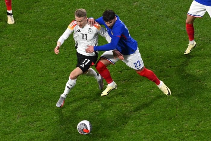 Im neuen DFB Trikot mit der Rückennummer 11: Chris Führich (CL) und Frankreichs Verteidiger #22 Theo Hernandez (CR) kämpfen um den Ball während des Freundschaftsspiels zwischen Frankreich und Deutschland im Groupama-Stadion in Decines-Charpieu, in der Nähe von Lyon, am 23. März 2024. (Foto: JEAN-PHILIPPE KSIAZEK / AFP)