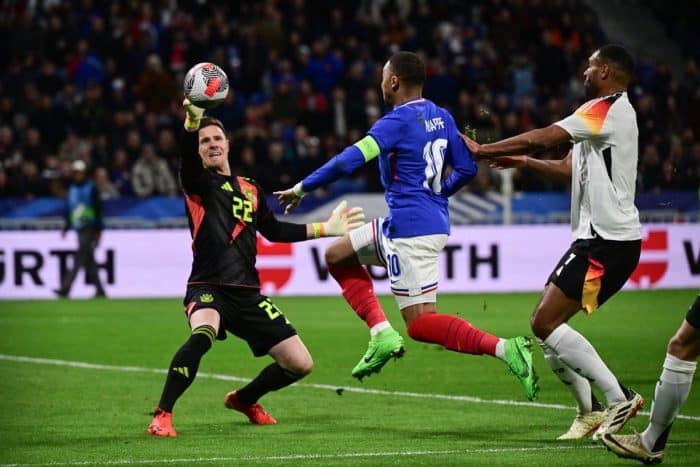 Im neuen DFB Torwarttrikot 2024: Der deutsche Torhüter (Rückennummer 22) Marc-Andre Ter Stegen (L) stoppt einen Schuss von Frankreichs Stürmer (10) Kylian Mbappe (C) während des Freundschaftsspiels zwischen Frankreich und Deutschland im Groupama-Stadion in Decines-Charpieu, in der Nähe von Lyon, am 23. März 2024. (Foto: Olivier CHASSIGNOLE / AFP)