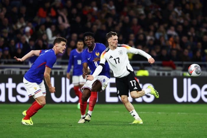 Frankreichs Mittelfeldspieler (Nr. 08) Aurelien Tchouameni (C) und Deutschlands Mittelfeldspieler (Nr. 17) Florian Wirtz (R) kämpfen um den Ball während des Freundschaftsspiels zwischen Frankreich und Deutschland im Groupama-Stadion in Decines-Charpieu, in der Nähe von Lyon, am 23. März 2024. (Foto: FRANCK FIFE / AFP)