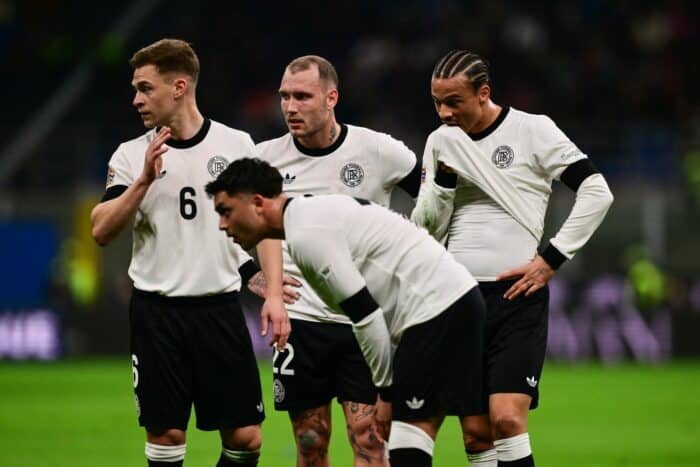 (v.l.) Der deutsche Mittelfeldspieler Joshua Kimmich (Nr. 06), der deutsche Verteidiger David Raum (Nr. 22) und der deutsche Verteidiger Maximilian Mittelstaedt (Nr. 18) schauen während des Viertelfinal-Hinspiels der Nations League zwischen Italien und Deutschland im San-Siro-Stadion in Mailand am 20. März 2025 zu. (Foto: Marco BERTORELLO / AFP)