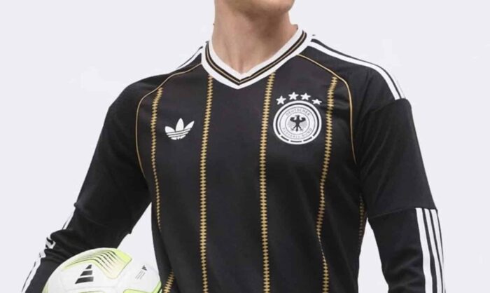 Das neue Deutschland Trikot in Schwarz: goldene Rautenlinien, weiß-gold gefasster V-Ausschnitt, Trefoil und historisches DFB-Wappen mit vier Sternen. (Bild: Footy Headlines)