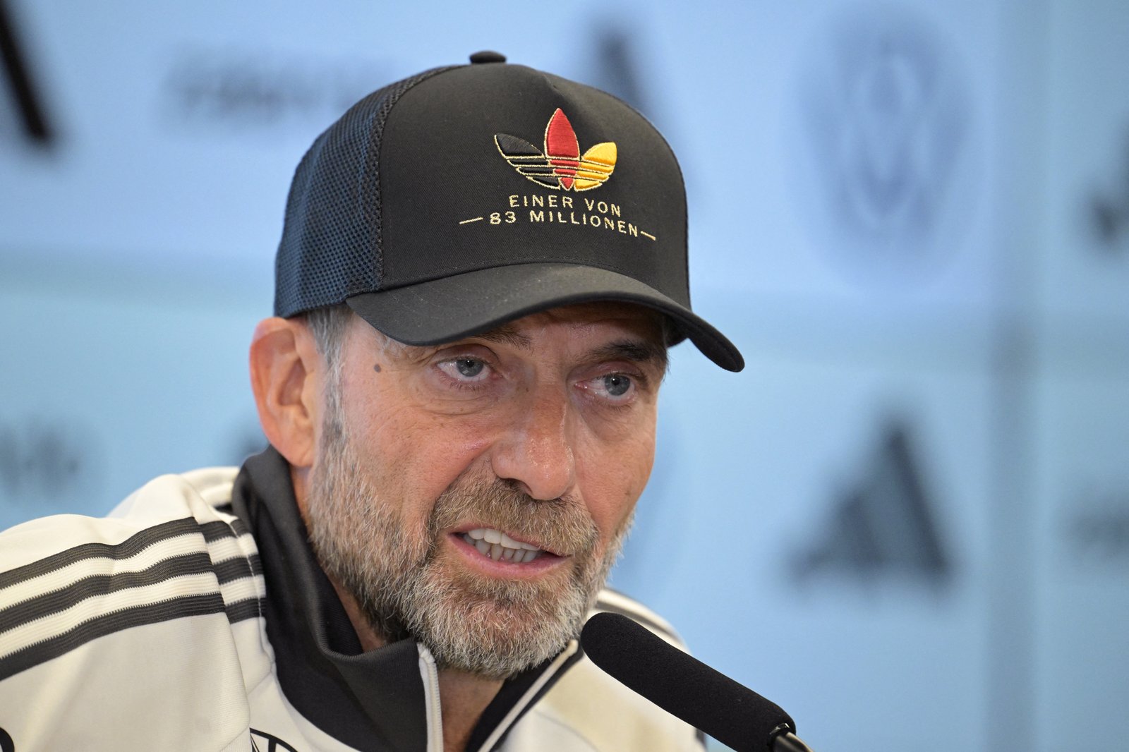 Bundestrainer Jürgen Klopp trägt bei der Vorstellung seines ersten Kaders am 17. September 2026 in der DFB-Zentrale in Frankfurt am Main seine schwarze Kappe mit dem Schriftzug „Einer von 83 Millionen“ und dem Trefoil-Logo in Schwarz-Rot-Gold. (Foto: Hannes P. Albert / AFP)