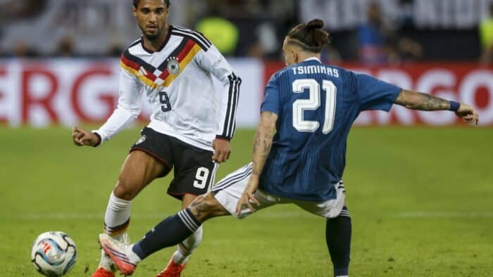 Kevin Schade im Zweikampf mit Konstantinos Tsimikas: Deutschland verlor das Nations-League-Spiel gegen Griechenland am 27. September 2026 in Augsburg mit 0:1. (Copyright AFP/Michaela Stache)